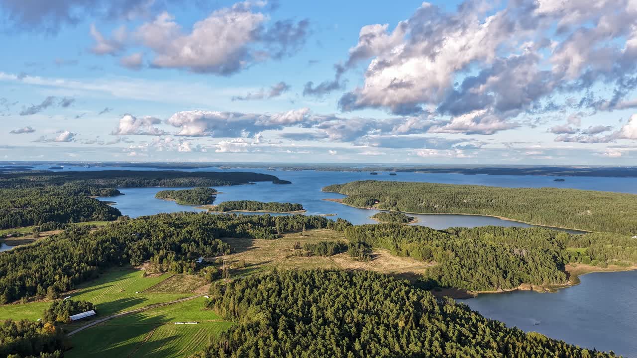 Drone hyperlapse over Finnish Turku Archipelago Sea. Sunny summer weather. Clouds and shadows moving over the scenery. High altitude moving aerial view