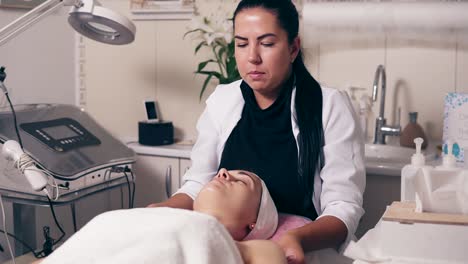 cosmetóloga femenina está haciendo masaje de cuello en el salón de spa