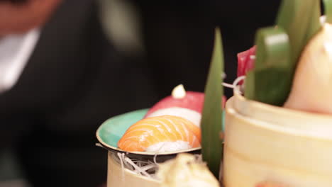 japanese chef at work producing fancy sushi and sashimi platter - close up shot