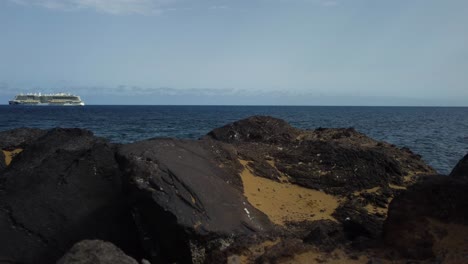 nice scene of rocks at the coast of spain in tenerife with boat yacht at the background drone shot in 4k sea seaside seashore ocean