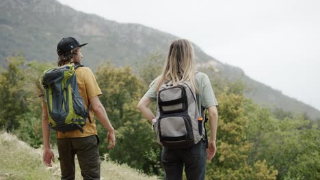 a happy couple backpackers hiking by hills, exploring new places