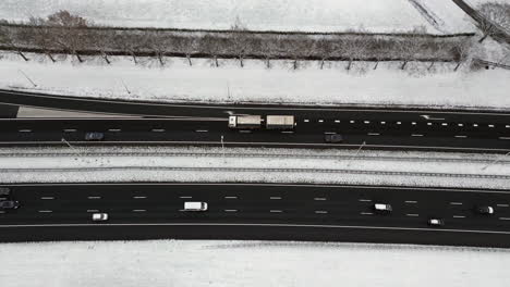 Highway-through-a-snowy-forest-landscape-seen-from-above