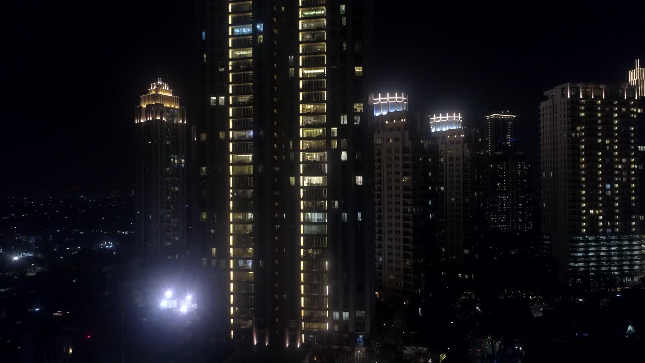 moving up by drone in the night with tall building