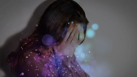 digital animation of upset woman covering her face. illuminated bubbles on foreground.