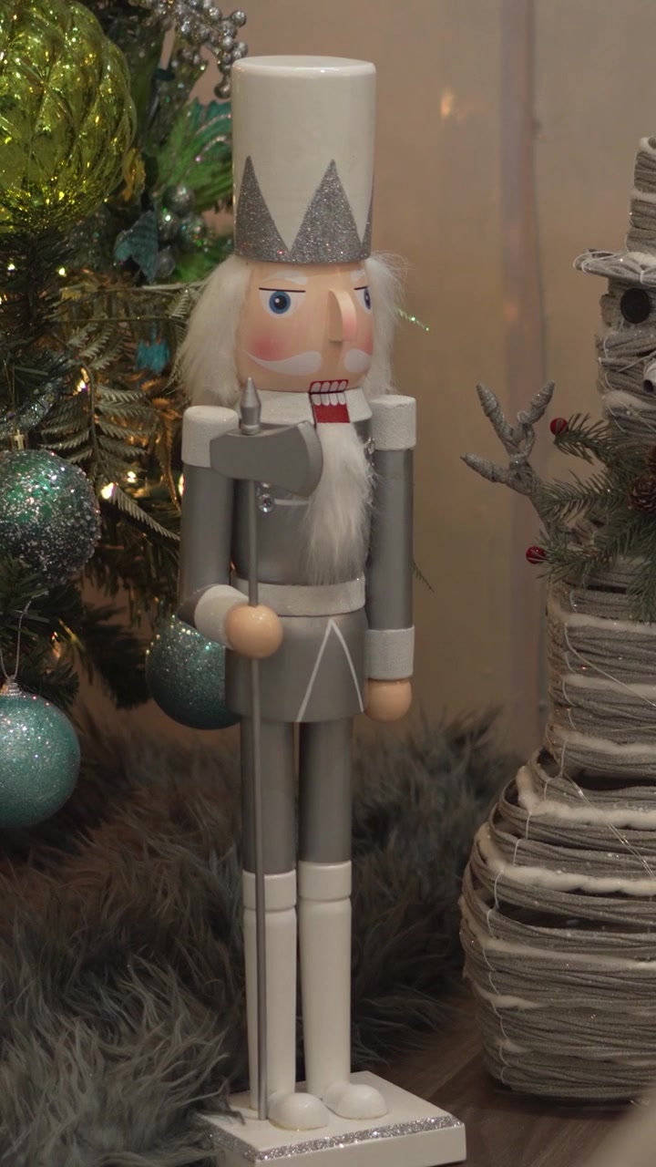 Close-up of decorative nutcracker and snowman figures decorating Christmas tree in living room at home.