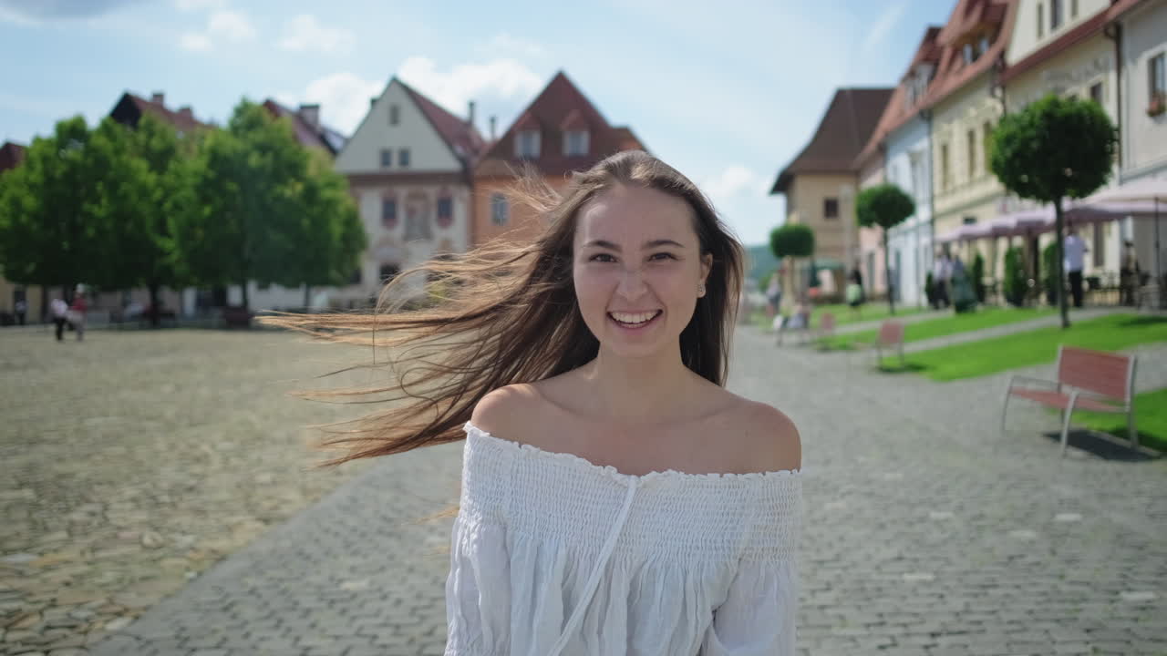 도시 광장에서 미소 짓는 젊은 여성