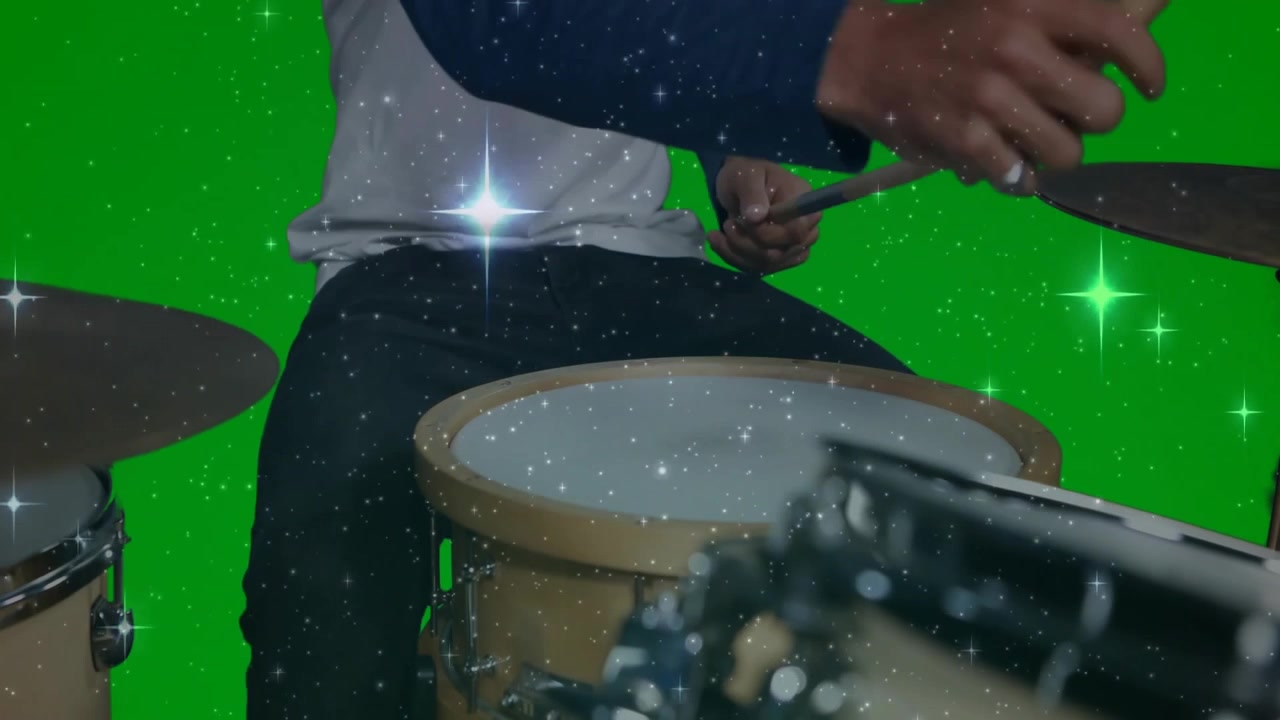 Male musician playing drums in music studio, with animated star sparkles overlaying green screen