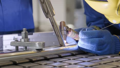 man wearing mask welding in a workshop. metal workers use manual labor. skilled welder. welder is welding the stainless steel pipes in the factory. welder industrial part in factory.