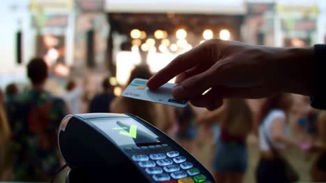 an engaging view of a live music event with a payment terminal in the foreground, highlighting the intersection of technology and entertainment at a festival atmosphere.