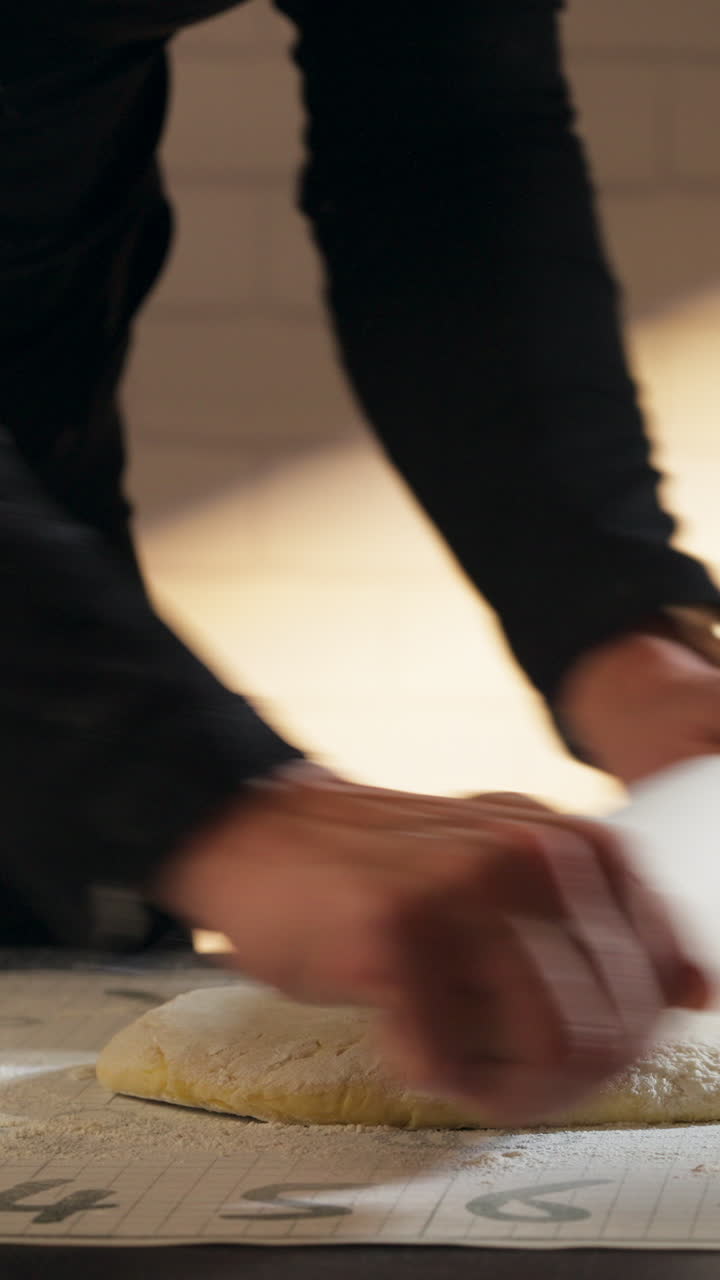Wooden Rolling Pin Being Used To Flatten Dough For Cinnamon Rolls. - vertical shot