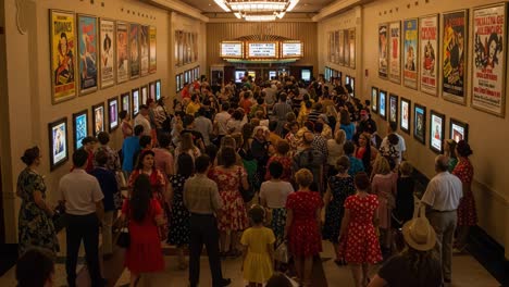a vibrant crowd gathered at a historic movie theater, capturing the essence of movie night with colorful outfits and classic film posters on display
