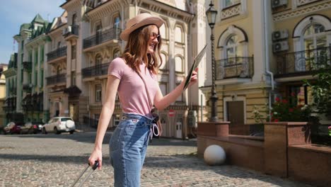 beautiful young woman tourist pleasant with city map and suitcase in the city center