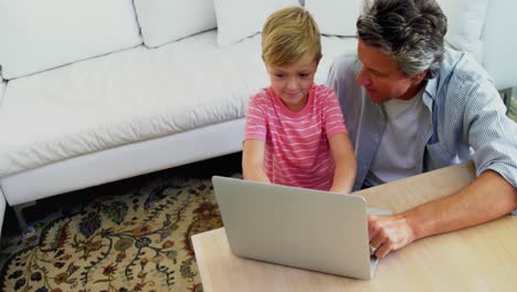 Vater-Und-Sohn-Benutzen-Laptop-Im-Wohnzimmer-4K