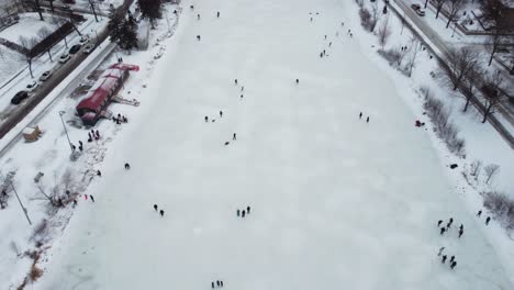 drone looking down on ice skaters on frozen lake of the isles in minneapolis, mn during winter