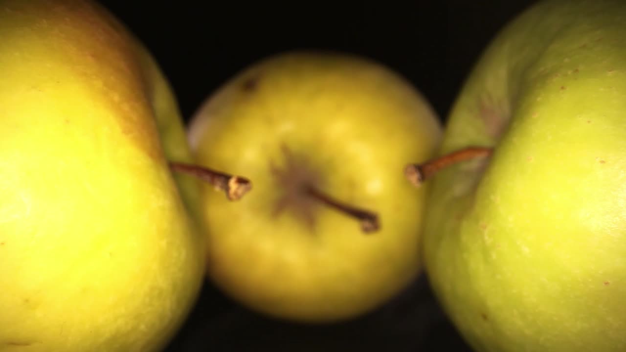 alejándose de 3 manzanas con tallos frente a la cámara