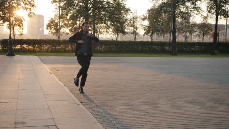 man dancing in a city park at sunset
