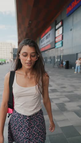 young woman walking in front of a shopping mall