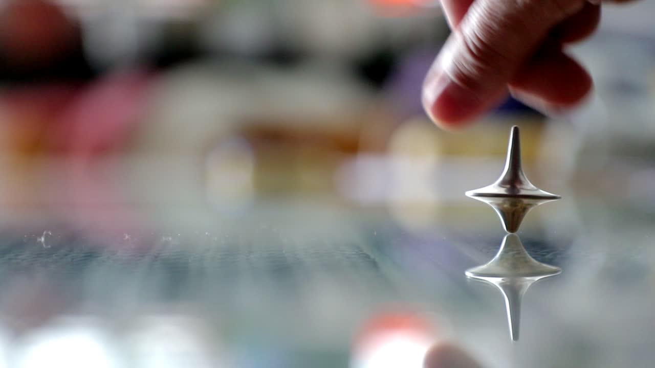 perinola girando sobre una mesa de vidrio en cámara lenta