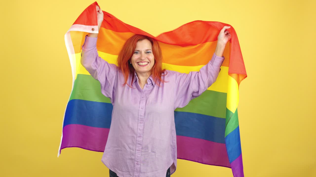 Happy Woman Celebrating with Rainbow Pride Flag on Yellow Background