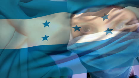 animación de ondear la bandera de honduras contra una cirujana caucásica que lleva una máscara quirúrgica en el hospital