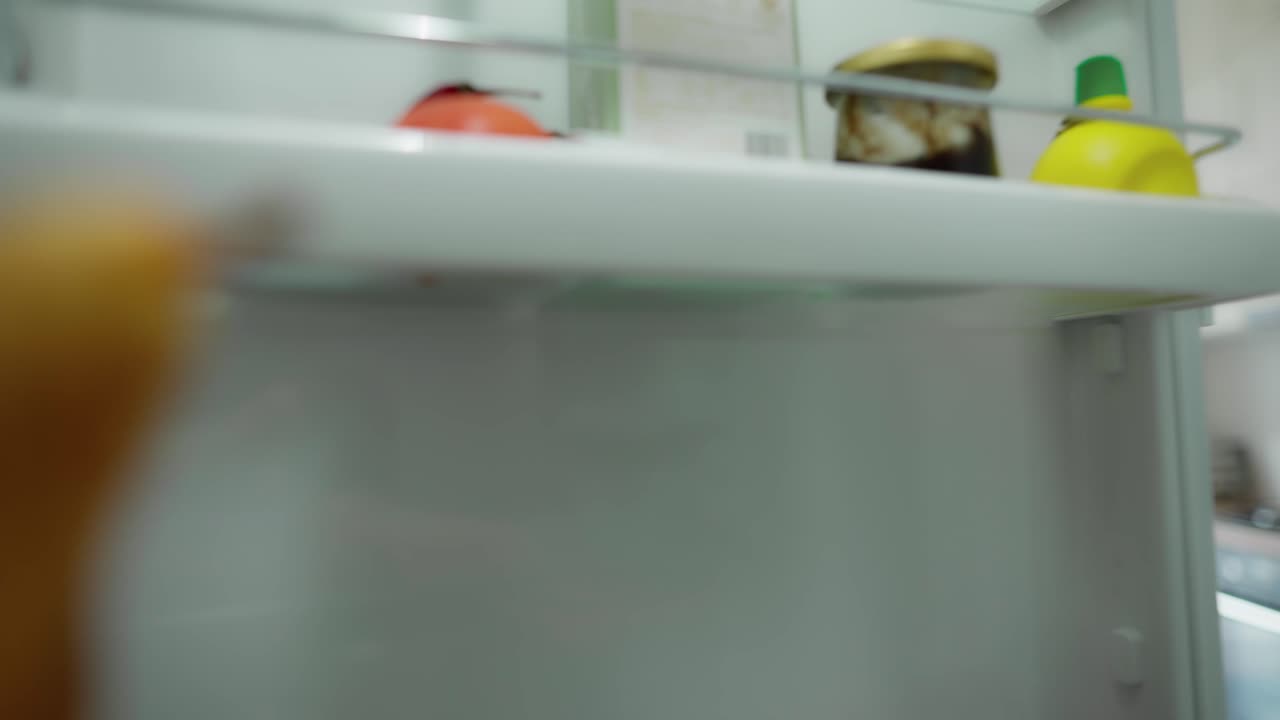 joven bonita tomando una manzana amarilla del refrigerador