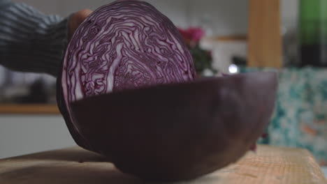 Nahaufnahme-Der-Hand-Einer-Frau,-Die-In-Der-Küche-Mit-Einem-Scharfen-Messer-Rotkohl-Schneidet