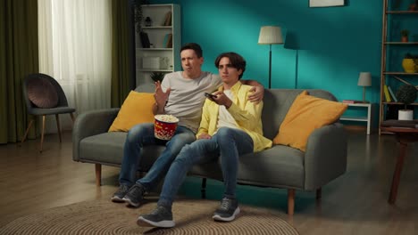 father and son watching tv together