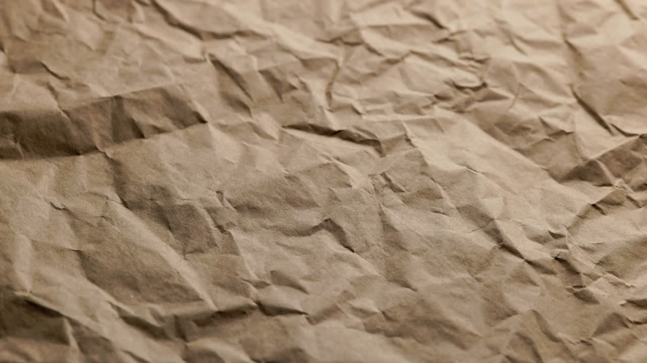 looped spinning close-up full-frame background of crumpled brown craft paper