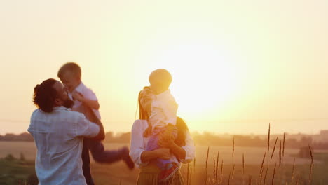 Junge-Familie-Mit-Zwei-Kindern,-Die-Bei-Sonnenuntergang-Auf-Der-Natur-Spielen