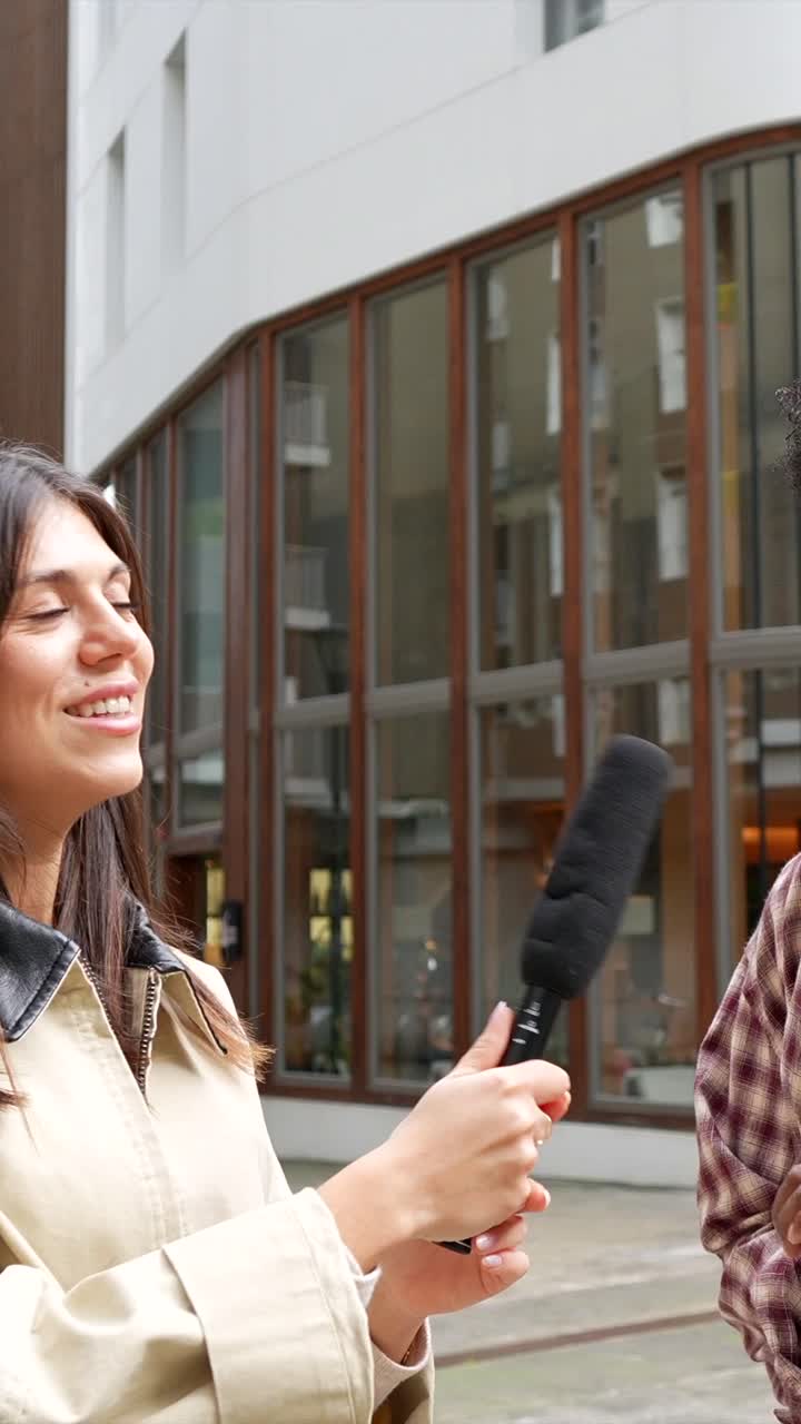 Woman Interviewing Man with Microphone Outdoors