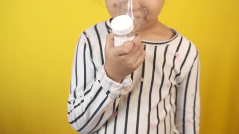 child using inhaler for asthma treatment