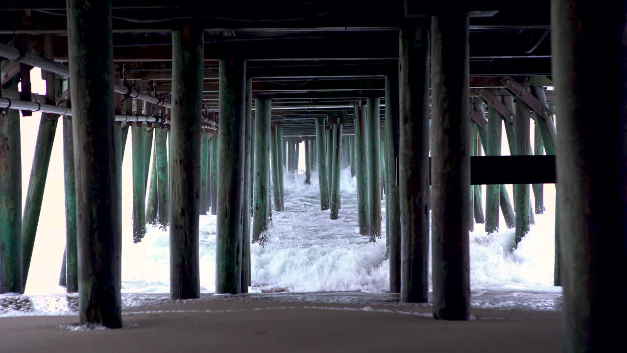 Waves crashing under pier in Maine