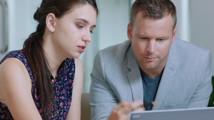 bella donna d'affari che usa un tablet che lavora con un uomo d'affari che condivide idee con colleghi che lavorano insieme in ufficio 4k
