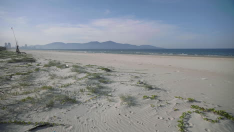 Reveal-shot-of-white-sand-beach-polluted-with-trash---a-washed-up-shoe-with-barnacles-indicates-how-long-at-sea-this-item-has-been-without-it-breaking-down