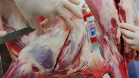 carnicero cortando carne en una fábrica de carne