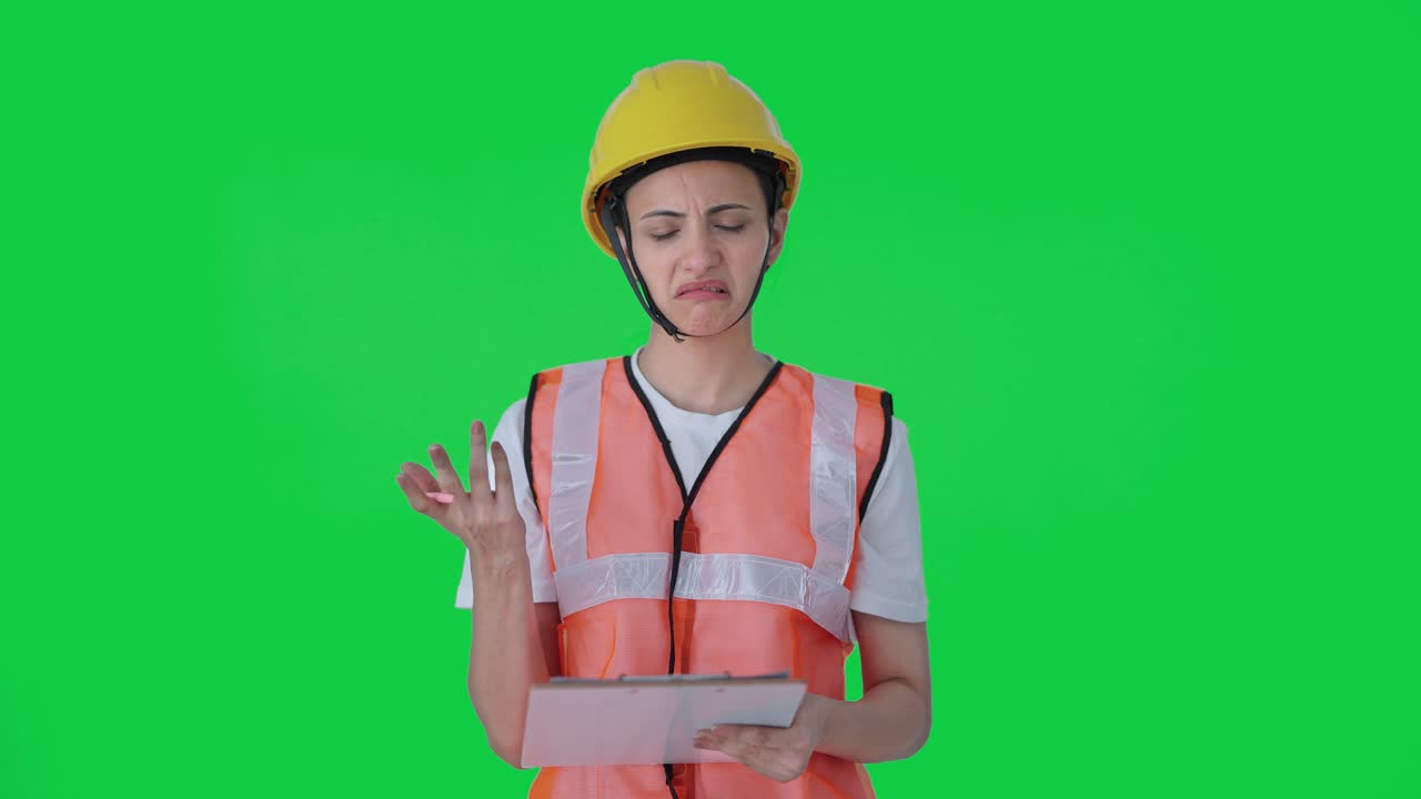 혼란스러운 인도 건설 노동자가 녹색 스크린을 만드는 메모를 취하고 있습니다.