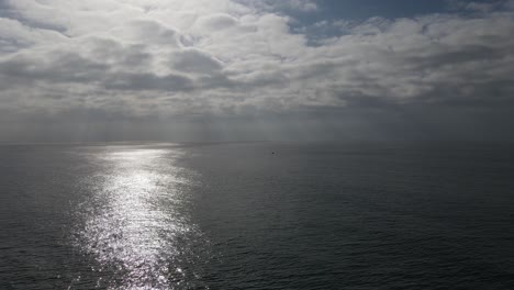 aerial flyover of ocean with sun rays