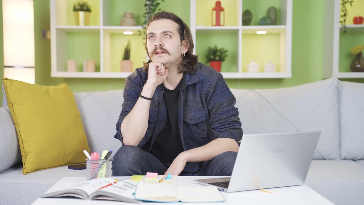 hombre sentado solo en casa pensando en momentos felices y sonriendo.