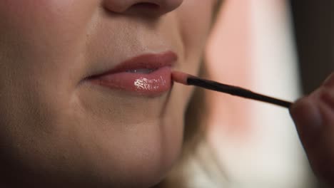 Seitliche-Zeitlupenansicht-Einer-Weiblichen-Lippe-Mit-Make-up-Künstlerin,-Die-Während-Ihres-Hochzeitstages-Lipgloss-Auf-Ihre-Lippen-Aufträgt