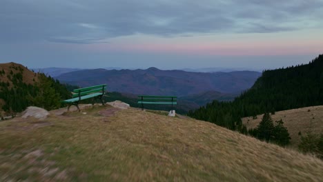 toma aérea reveladora detrás del borde del monte dichiu que muestra el paisaje verde del bosque en el valle durante el anochecer - europa, rumania