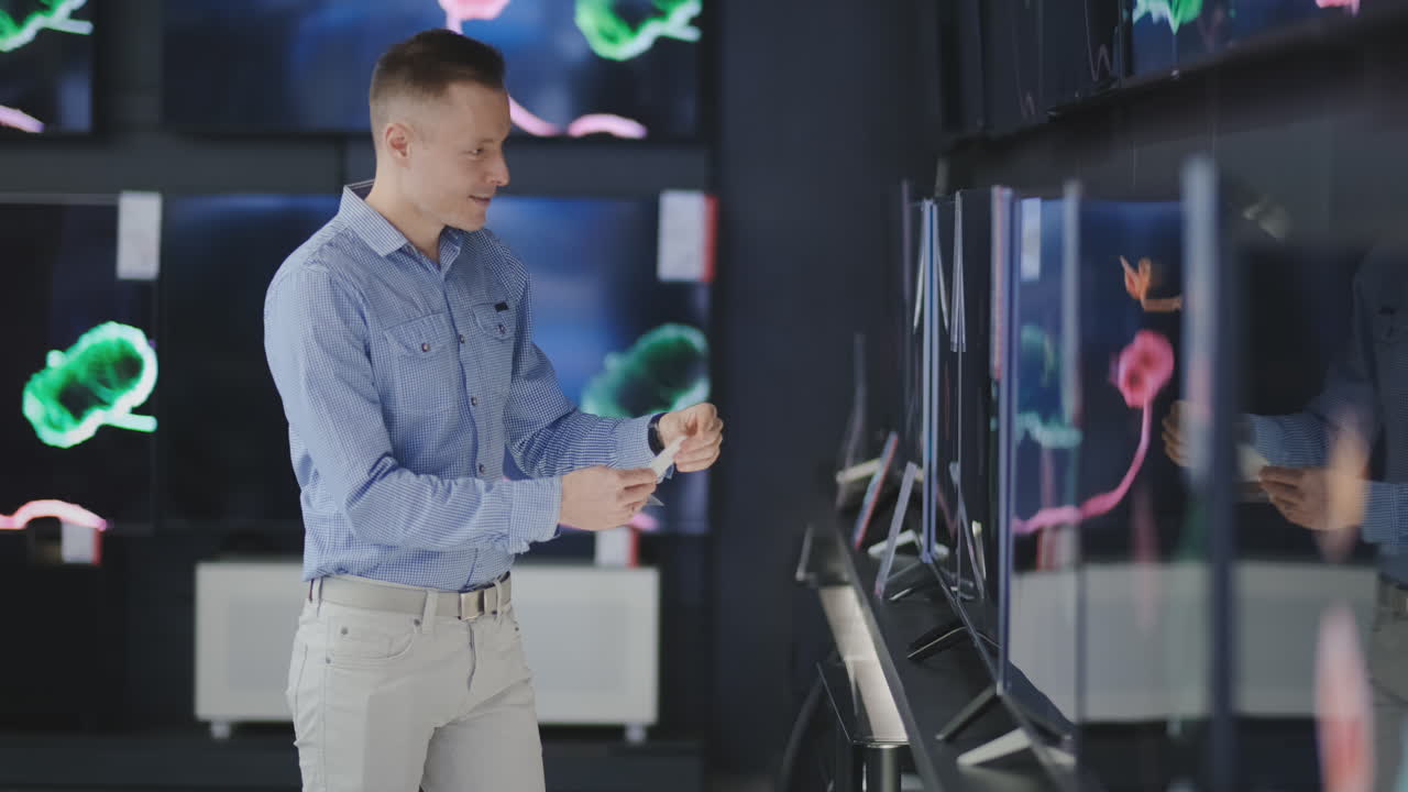 Man at tech store shopping new TV. Looking for a new big screen. Shopping time.