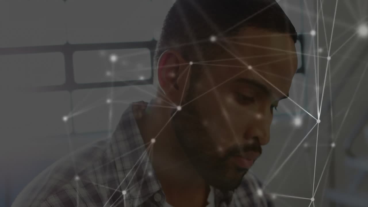 Man tapping tablet screen at desk, activating digital network overlay for design prototype