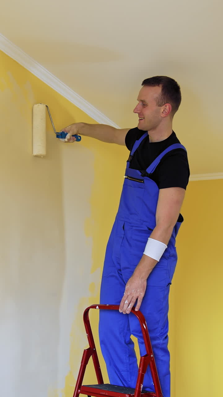 Young colorist doing new renovation in house. Painter decorating with color indoor. Vertical video