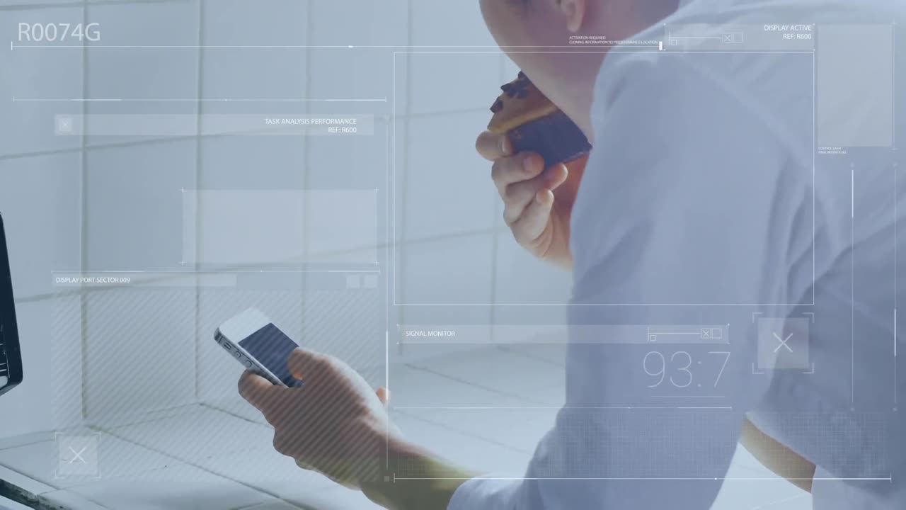 una persona usando un teléfono móvil mientras come un muffin en una cocina en casa.