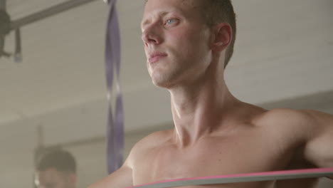 man exercising with resistance band in gym