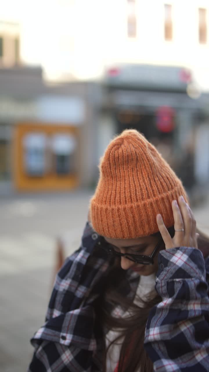 mujer con un sombrero de punto naranja y una camisa a cuadros