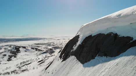 winter mountainscape with frozen snowdrift overhanging cliff