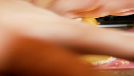 Female-hands-are-using-a-wooden-rolling-pin-for-gingerbread-cookie-dough