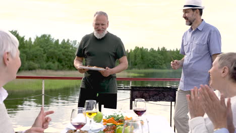 two senior friends are serving the dinner outside