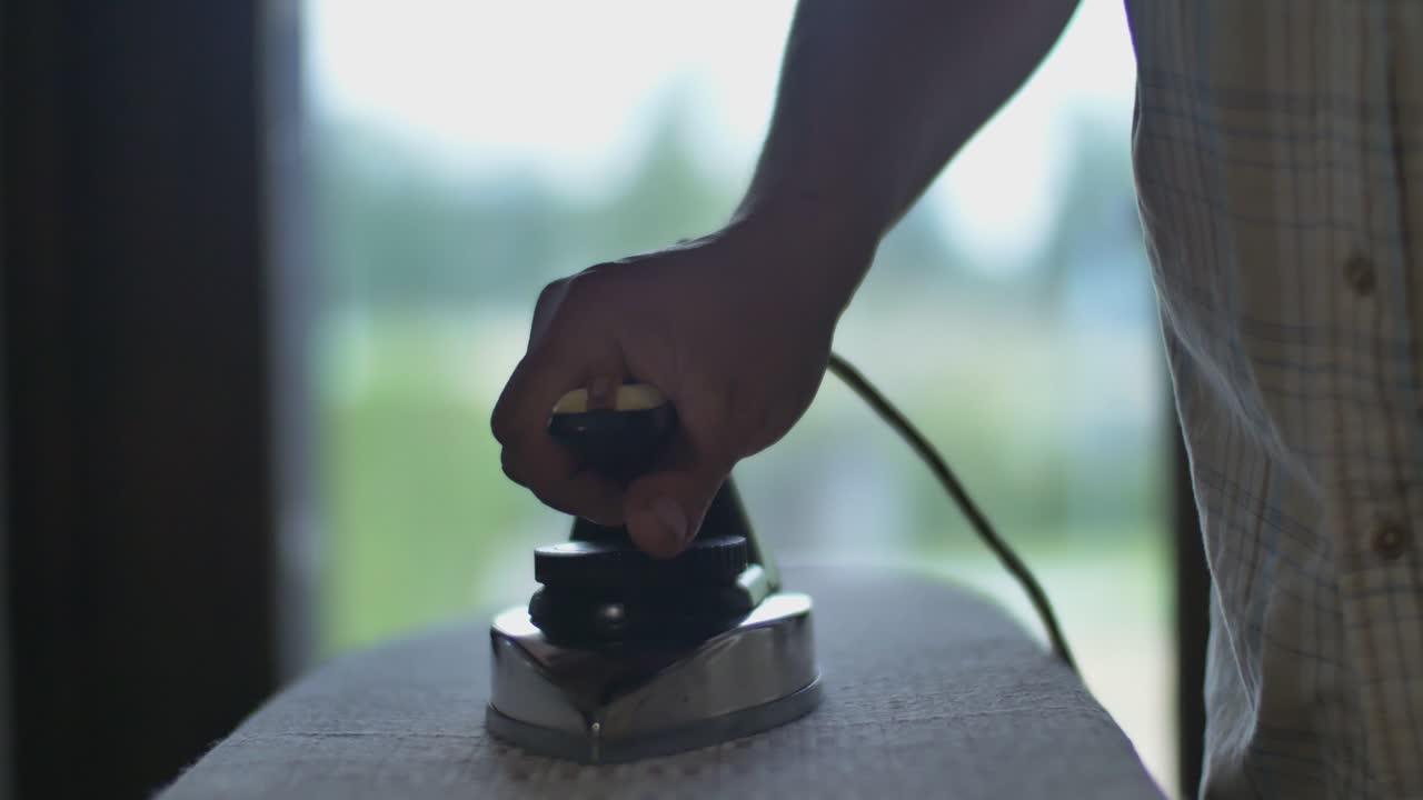 Man Smoothes the Fabric with an Old Vintage Soviet Iron